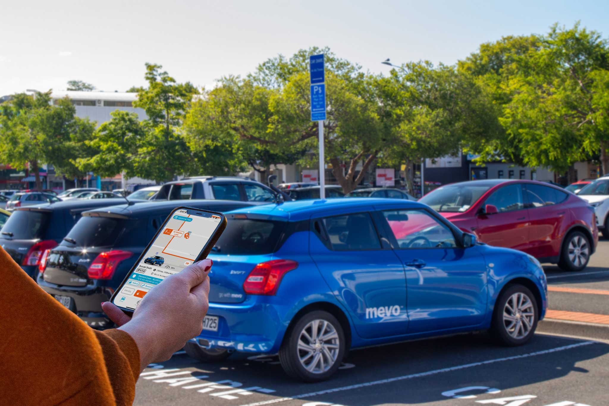 Woman unlocking a Mevo car with her phone in Buxton Square, Nelson