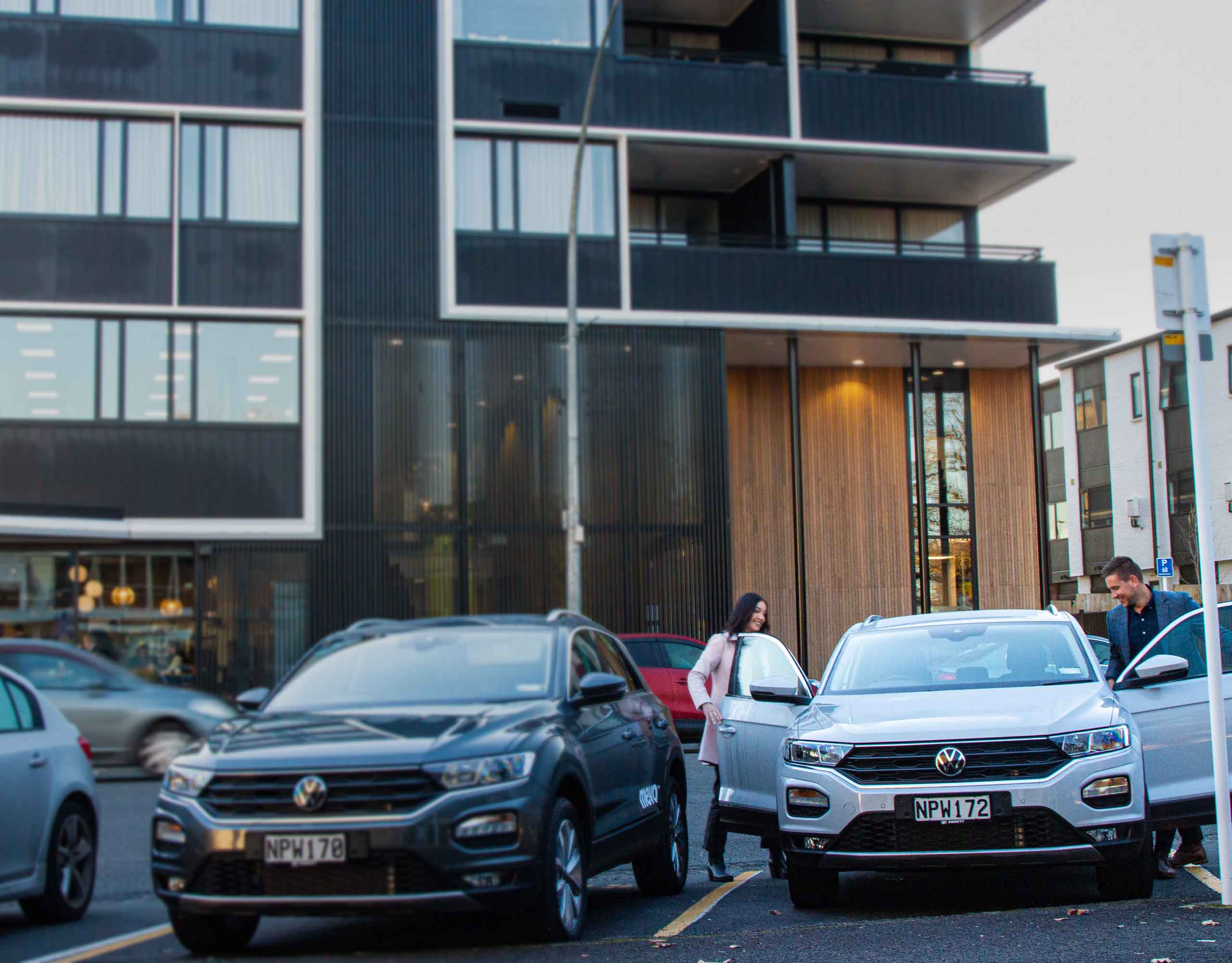 People on a city street getting into a Mevo car