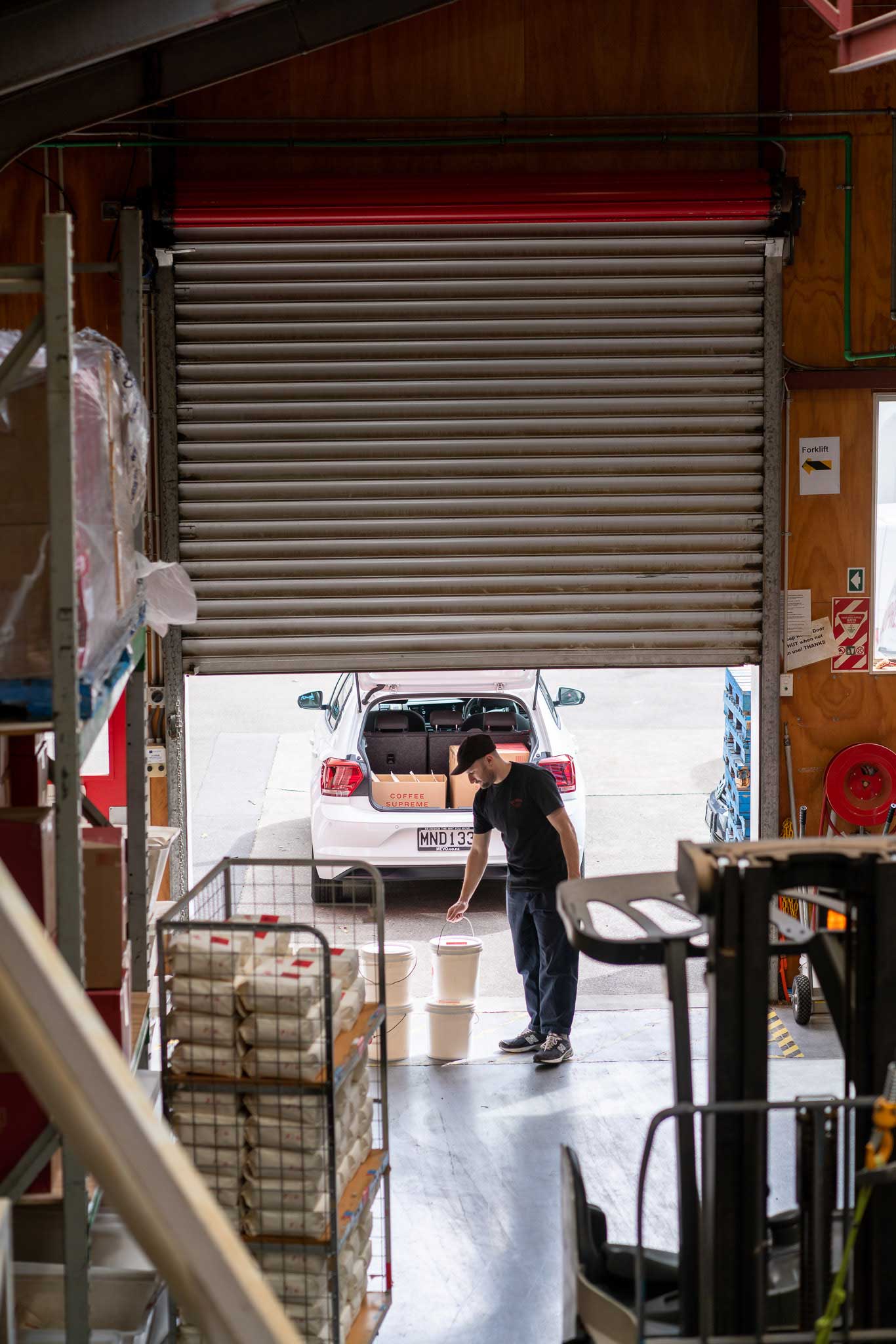 Tim loading coffee into the back of a Mevo car.