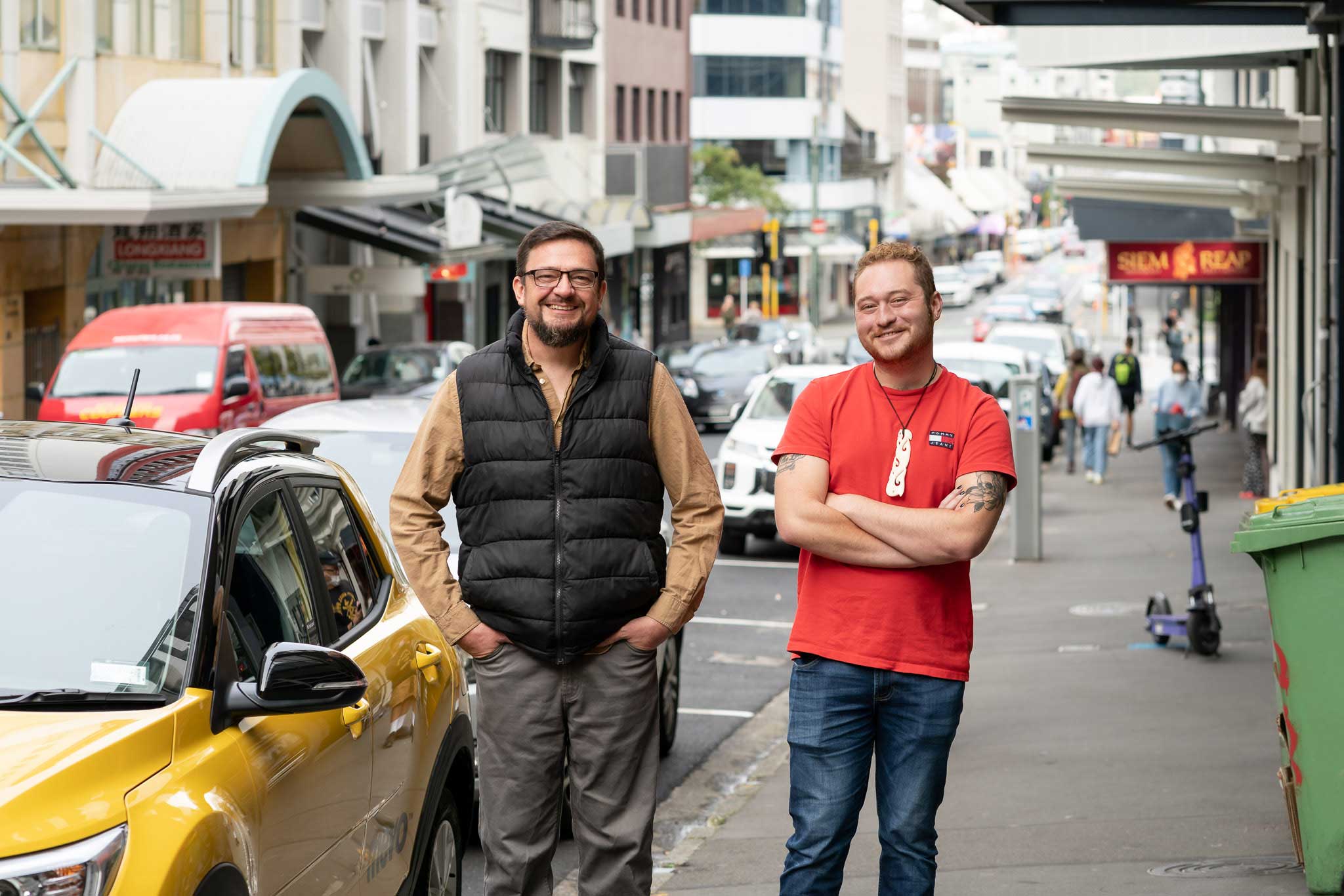 Jason and his partner standing in front of a Mevo vehicle in Central Wellington.